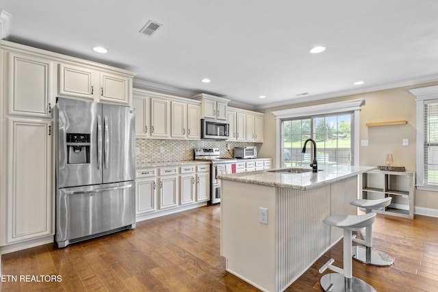 1017 Brighton Dr, Alcoa, TN 37701 - kitchen with appliances with stainless steel finishes, a sink, hardwood / wood-style flooring, light stone counters, and ornamental molding