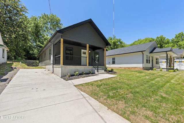 1219 NW Dakota Ave, Knoxville, TN 37921 - view of front of property featuring covered porch, a front yard, and concrete driveway