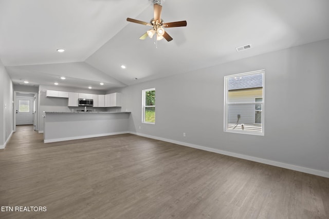 1219 NW Dakota Ave, Knoxville, TN 37921 - unfurnished living room featuring lofted ceiling, wood finished floors, baseboards, ceiling fan, and recessed lighting