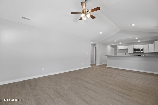 1219 NW Dakota Ave, Knoxville, TN 37921 - unfurnished living room featuring vaulted ceiling, light wood-style floors, a ceiling fan, recessed lighting, and baseboards