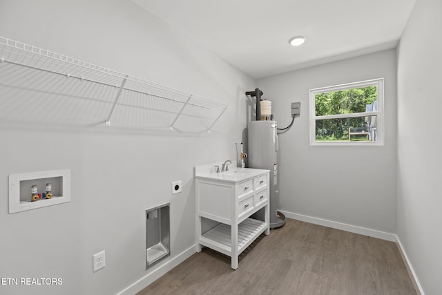 1219 NW Dakota Ave, Knoxville, TN 37921 - laundry area with electric dryer hookup, hookup for a washing machine, electric water heater, baseboards, and wood finished floors
