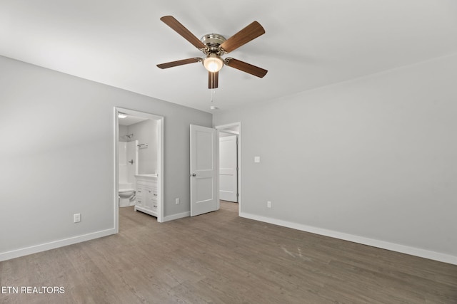 1219 NW Dakota Ave, Knoxville, TN 37921 - unfurnished bedroom with wood finished floors, baseboards, ensuite bath, and a ceiling fan