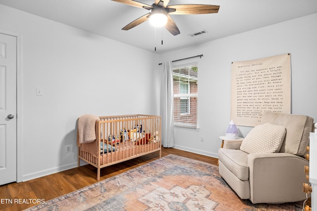 1625 Linden Hall Dr, Alcoa, TN 37701 - bedroom with wood finished floors, a crib, and a ceiling fan