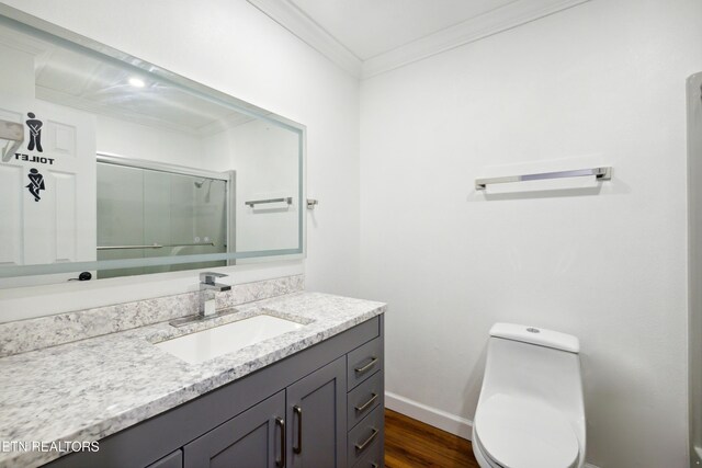 566 Allyson Dr, Kodak, TN 37764 - bathroom featuring vanity, ornamental molding, toilet, wood finished floors, and a shower with door