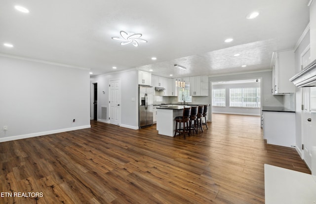566 Allyson Dr, Kodak, TN 37764 - kitchen with stainless steel fridge, ornamental molding, dark countertops, white cabinetry, and dark wood-type flooring