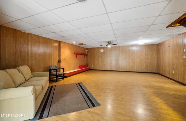 566 Allyson Dr, Kodak, TN 37764 - unfurnished living room featuring wood finished floors, a drop ceiling, wood walls, and baseboards