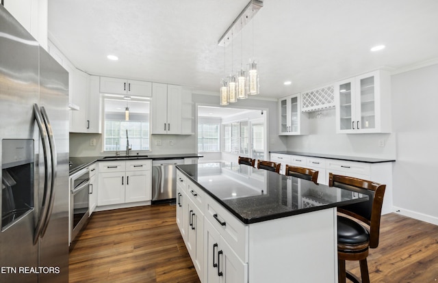 566 Allyson Dr, Kodak, TN 37764 - kitchen with appliances with stainless steel finishes, a sink, dark wood finished floors, ornamental molding, and a breakfast bar area