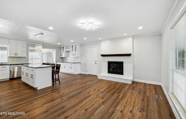 566 Allyson Dr, Kodak, TN 37764 - kitchen with stainless steel dishwasher, dark countertops, a breakfast bar, white cabinetry, and glass insert cabinets