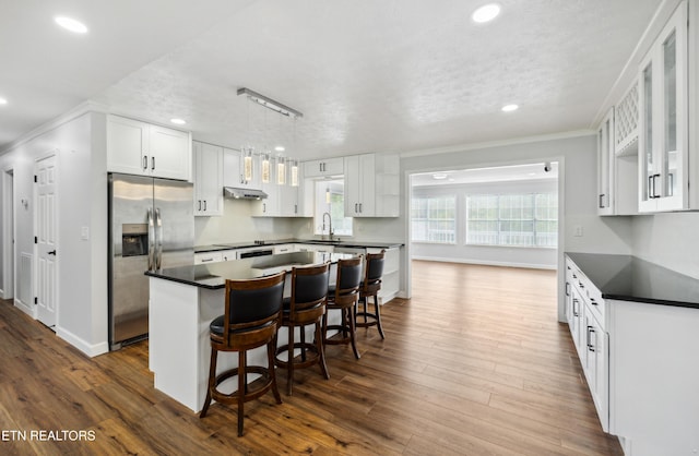 566 Allyson Dr, Kodak, TN 37764 - kitchen with stainless steel refrigerator with ice dispenser, dark countertops, ornamental molding, a kitchen island, and recessed lighting