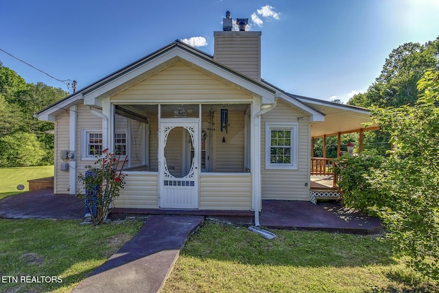 883 Old Harriman Hwy, Harriman, TN 37748 - view of front of home featuring a front yard, a chimney, a sunroom, and a patio area