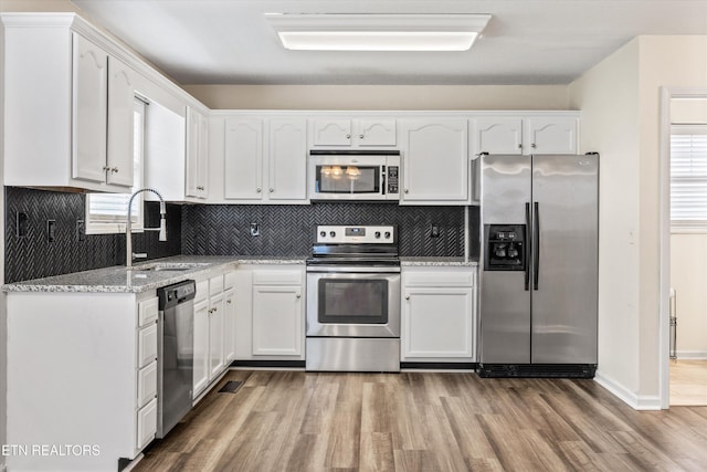 9934 Thunderbolt Way, Knoxville, TN 37923 - kitchen with stainless steel appliances, a sink, white cabinets, and wood finished floors
