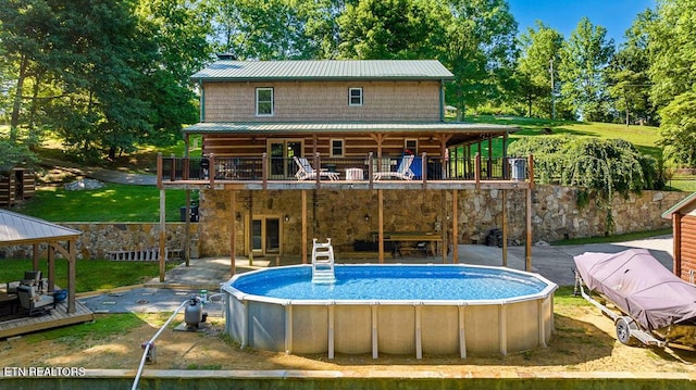 257 Copenhaver Rd, Lenoir City, TN 37771 - rear view of property featuring a wooden deck, an outdoor pool, stone siding, metal roof, and a gazebo