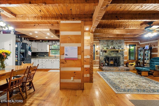 257 Copenhaver Rd, Lenoir City, TN 37771 - kitchen featuring black fridge, wooden ceiling with exposed beams, light wood-style flooring, white cabinets, and open floor plan