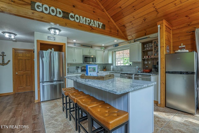 129 Bridgeview Ln, Lafollette, TN 37766 - kitchen with appliances with stainless steel finishes, tasteful backsplash, vaulted ceiling, a kitchen island, and open shelves
