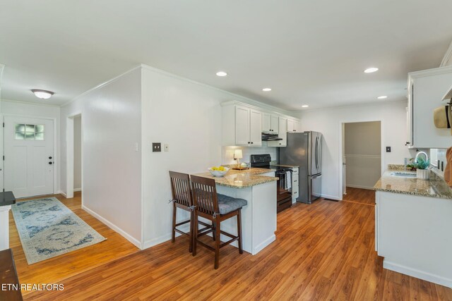 824 Noragate Rd, Knoxville, TN 37919 - kitchen featuring black electric range, a sink, freestanding refrigerator, under cabinet range hood, and white cabinets