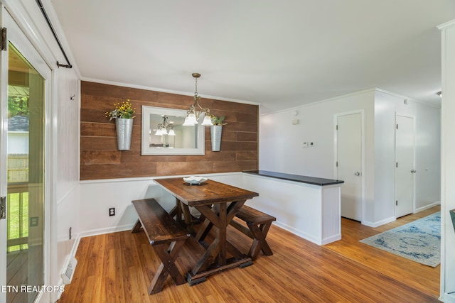 824 Noragate Rd, Knoxville, TN 37919 - dining space with wood finished floors, a chandelier, wooden walls, baseboards, and crown molding