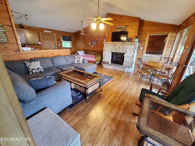 2859 Eagle Crest Way, Sevierville, TN 37876 - living room featuring vaulted ceiling, wood walls, healthy amount of natural light, ceiling fan, and wood finished floors