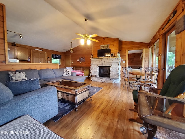 2859 Eagle Crest Way, Sevierville, TN 37876 - living area featuring wooden walls, wood-type flooring, vaulted ceiling, a stone fireplace, and ceiling fan