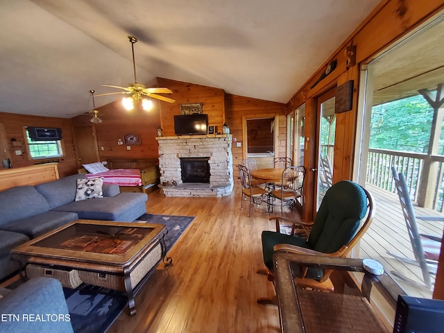 2859 Eagle Crest Way, Sevierville, TN 37876 - living area featuring lofted ceiling, wood walls, a stone fireplace, wood finished floors, and ceiling fan