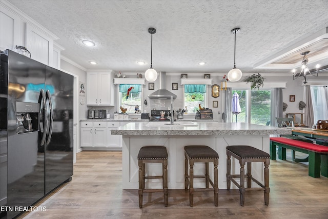 235 Neely Dr, New Tazewell, TN 37825 - kitchen featuring black refrigerator with ice dispenser, wall chimney exhaust hood, healthy amount of natural light, white cabinets, and crown molding