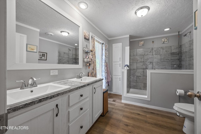 235 Neely Dr, New Tazewell, TN 37825 - full bathroom featuring tiled shower, double vanity, a textured ceiling, wood finished floors, and ornamental molding