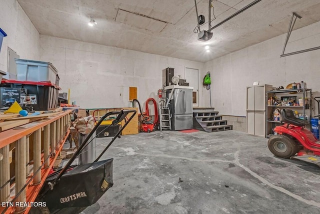 108 W Bobcat Ln, Wilder, TN 38589 - garage featuring freestanding refrigerator, a workshop area, and a garage door opener