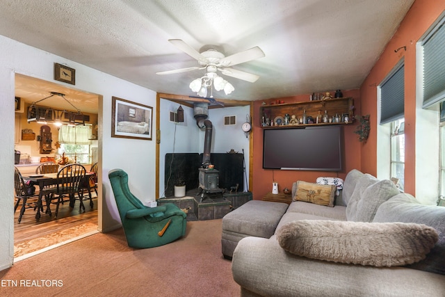 4349 Locust Ridge Rd, Sevierville, TN 37876 - living room featuring a wood stove, carpet, ceiling fan, and a textured ceiling