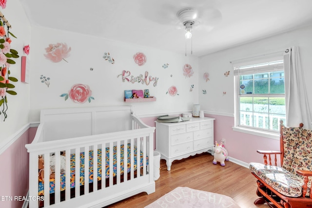 6608 Hickory Way Ln, Knoxville, TN 37918 - bedroom with a crib, light wood finished floors, a ceiling fan, and baseboards