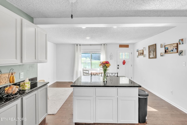 6608 Hickory Way Ln, Knoxville, TN 37918 - kitchen featuring a textured ceiling, light wood-type flooring, white cabinets, baseboards, and dark stone countertops
