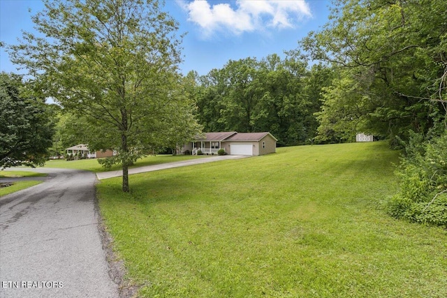 68 Pine Mountain Cir, Pineville, KY 40977 - view of front of property featuring asphalt driveway, a garage, a front yard, and a wooded view