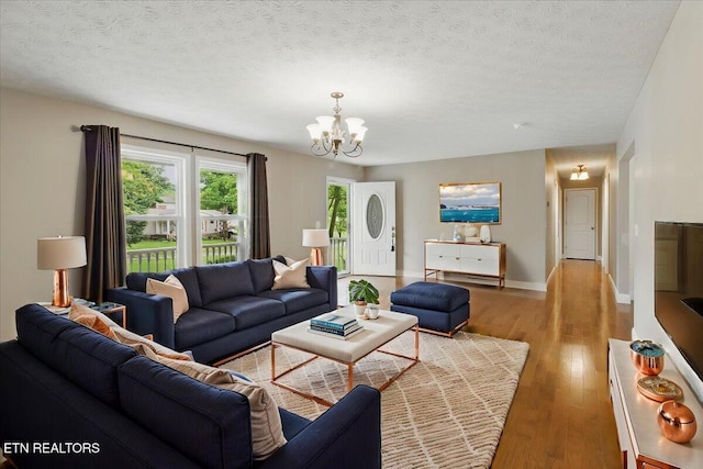 68 Pine Mountain Cir, Pineville, KY 40977 - living area with a chandelier, light wood finished floors, baseboards, and a textured ceiling