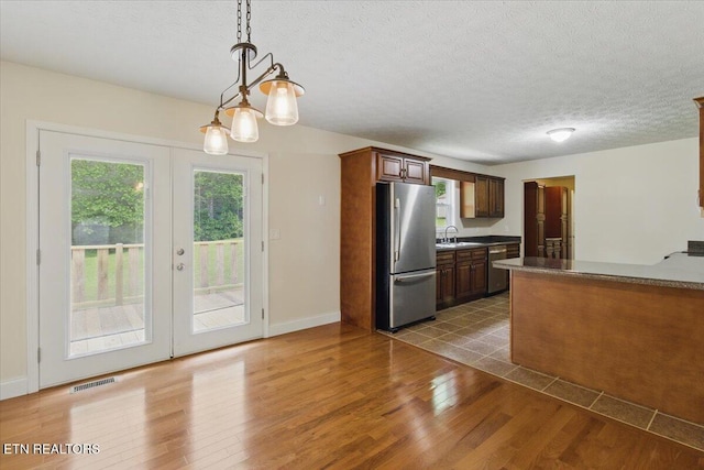 68 Pine Mountain Cir, Pineville, KY 40977 - kitchen featuring stainless steel appliances, a sink, french doors, light wood-type flooring, and hanging light fixtures