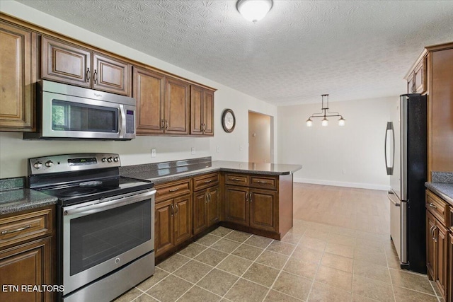 68 Pine Mountain Cir, Pineville, KY 40977 - kitchen featuring stainless steel appliances, dark countertops, a peninsula, a textured ceiling, and baseboards