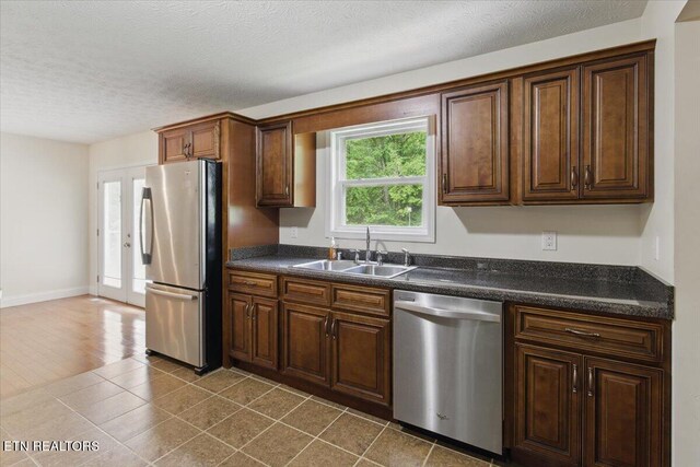 68 Pine Mountain Cir, Pineville, KY 40977 - kitchen featuring stainless steel appliances, a sink, dark countertops, a textured ceiling, and dark tile patterned floors