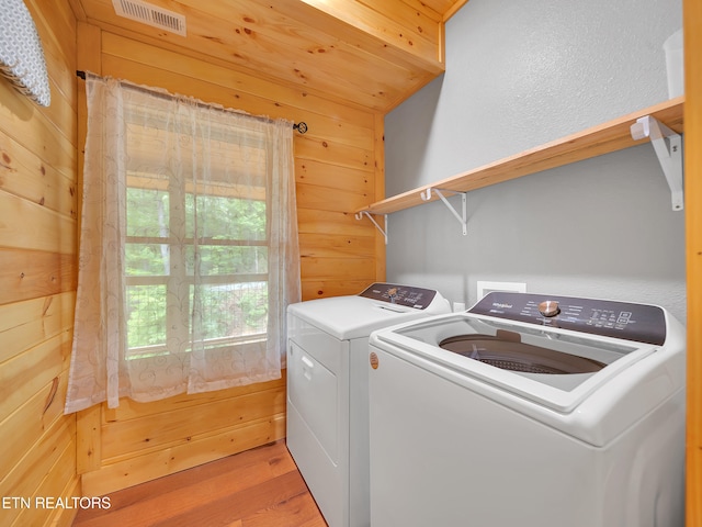 1027 Leslie Way, Sevierville, TN 37876 - laundry area with washing machine and dryer, wooden walls, and light wood finished floors