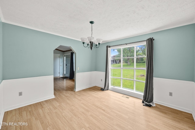 1036 Hawthorn Dr, Cookeville, TN 38501 - spare room with arched walkways, a textured ceiling, a chandelier, wood finished floors, and crown molding