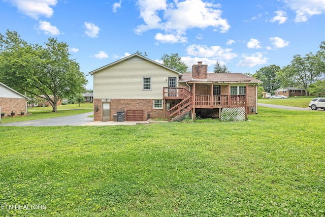 1036 Hawthorn Dr, Cookeville, TN 38501 - rear view of house featuring brick siding, a deck, a chimney, stairway, and a lawn