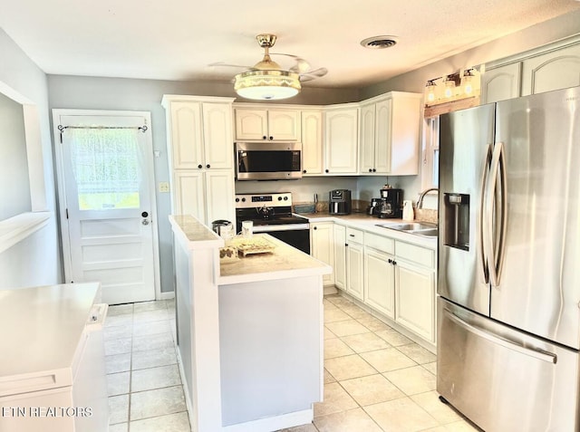 4721 Springcrest Dr, Knoxville, TN 37914 - kitchen with appliances with stainless steel finishes, a sink, a kitchen island, light tile patterned floors, and light countertops