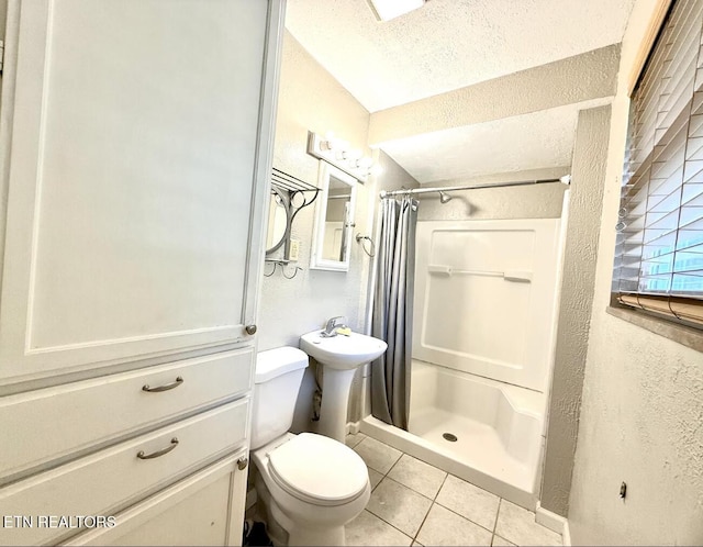 4721 Springcrest Dr, Knoxville, TN 37914 - full bath with tile patterned flooring, a shower stall, toilet, a textured wall, and baseboards