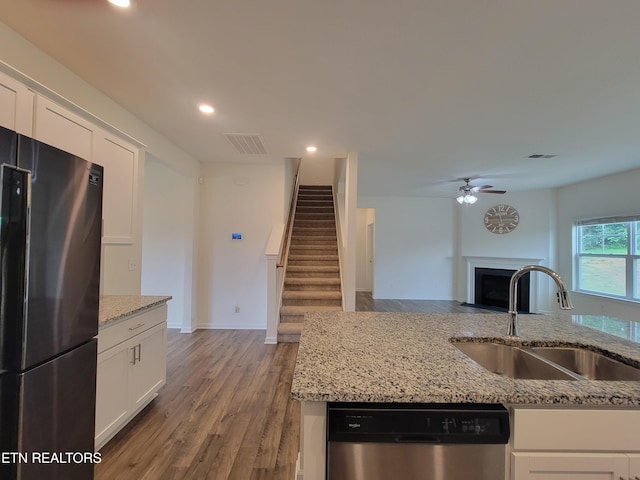 12043 Lillibridge Crossing Ln, Knoxville, TN 37932 - kitchen featuring freestanding refrigerator, stainless steel dishwasher, a sink, a fireplace with flush hearth, and ceiling fan