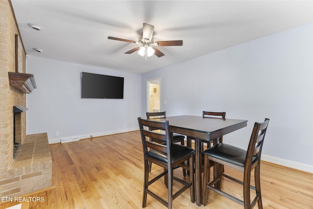 120 Cooper Cir, Oak Ridge, TN 37830 - dining space with a fireplace, a ceiling fan, light wood-style flooring, and baseboards