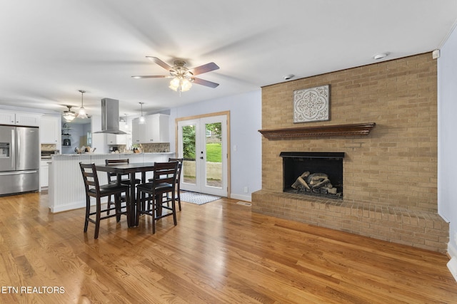 120 Cooper Cir, Oak Ridge, TN 37830 - dining space featuring ceiling fan, a brick fireplace, wood finished floors, and french doors