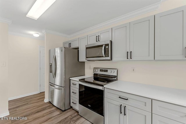 1213 Vale View Rd, Knoxville, TN 37922 - kitchen with appliances with stainless steel finishes, light countertops, light wood finished floors, baseboards, and ornamental molding