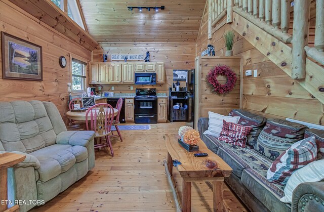 2261 Beach Front Dr, Sevierville, TN 37876 - living room featuring light wood-style flooring, wooden walls, and vaulted ceiling