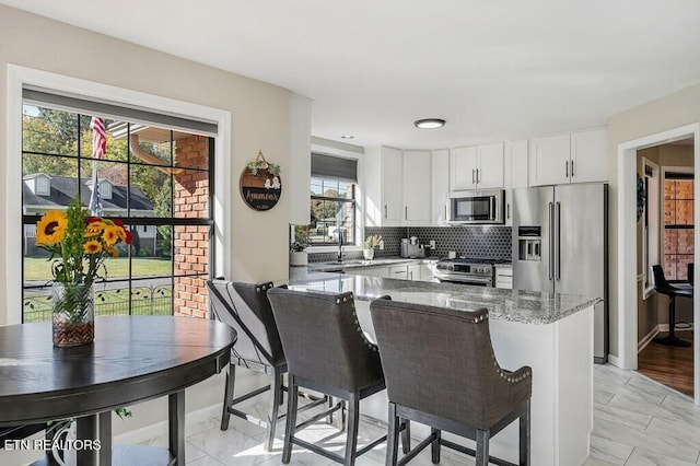 236 Stratford Dr, Cookeville, TN 38506 - kitchen with appliances with stainless steel finishes, light stone counters, white cabinetry, tasteful backsplash, and a peninsula