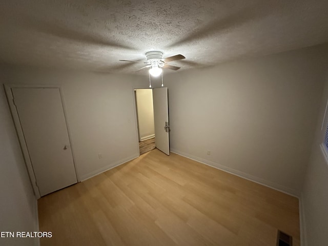 105 Mudlick Rd, Middlesboro, KY 40965 - empty room with light wood-type flooring, a ceiling fan, baseboards, and a textured ceiling