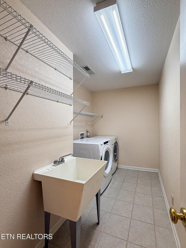 11104 Joiner Way, Knoxville, TN 37934 - laundry area with washer and dryer, a textured ceiling, light tile patterned floors, and baseboards