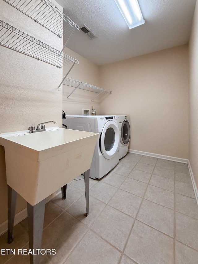 11104 Joiner Way, Knoxville, TN 37934 - laundry room featuring independent washer and dryer, baseboards, light tile patterned flooring, and a textured ceiling