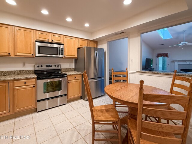 11104 Joiner Way, Knoxville, TN 37934 - kitchen featuring appliances with stainless steel finishes, a skylight, recessed lighting, light tile patterned floors, and light stone counters