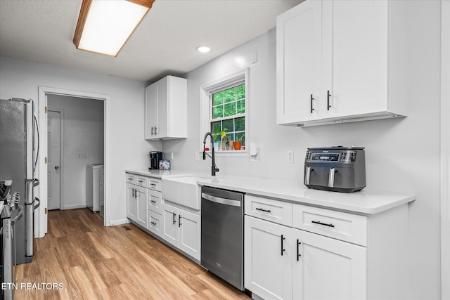 2236 Spruce Loop, Crossville, TN 38555 - kitchen with stainless steel appliances, a sink, light wood finished floors, white cabinetry, and light countertops